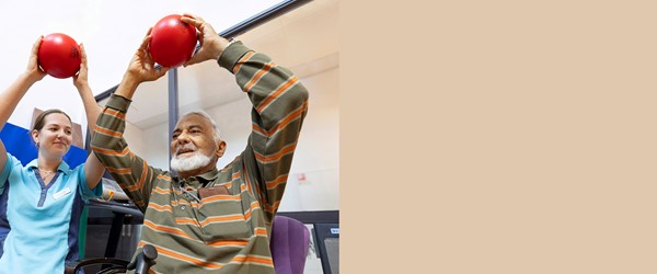 Fysiotherapeut en man doen oefening met bal