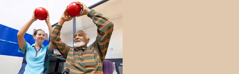 Fysiotherapeut en man doen oefening met bal