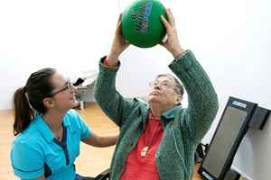 Fysiotherapeut en man doen oefening met bal